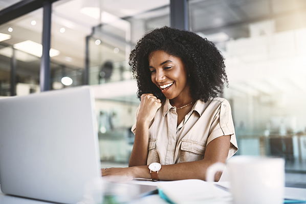 A woman smiling while using a laptop