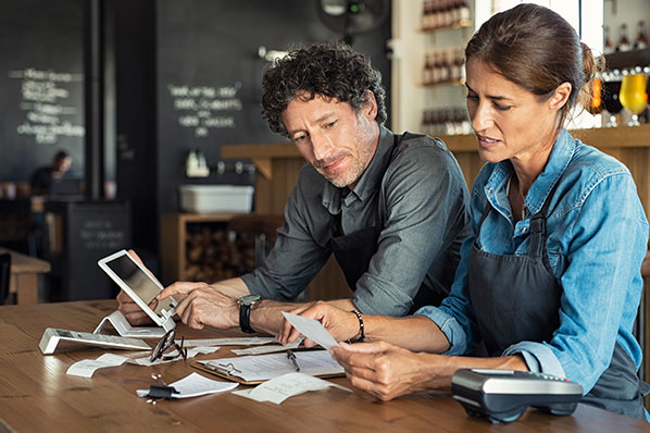 A man and a woman reviewing receipts at a table