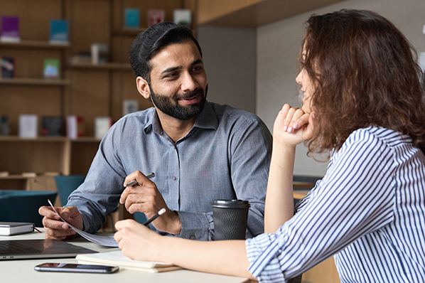 Two people having a discussion at a desk