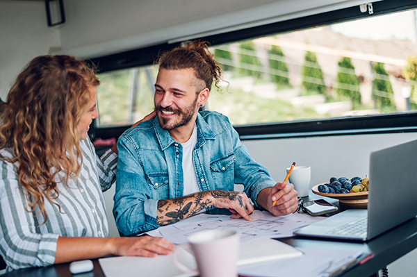 A man and a woman reviewing home plans at a table