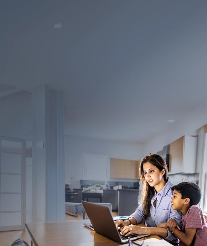 A woman on a laptop sitting next to her son